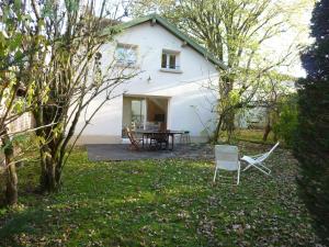 a white house with a table and chairs in the yard at Gîte du Tilleul in Vienne