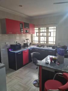 a kitchen with red cabinets and a counter top at Chic 4 Bed bungalow Oluyole Akala express Ibadan in Ibadan