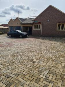 un coche aparcado frente a una casa de ladrillo en Chic 4 Bed bungalow Oluyole Akala express Ibadan, en Ibadán