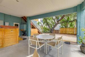 un patio con mesa, sillas y un árbol en Vibrant Condo - Walk to Indian Rocks Beach!, en Clearwater Beach
