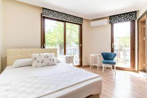 1 dormitorio con 1 cama grande y 1 silla azul en Salida İnn Kuşadası, en Kusadasi