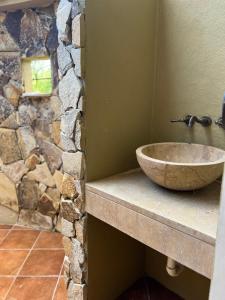 Baño con lavabo de piedra y pared de piedra en Pavones Beach Resort, en Pavones