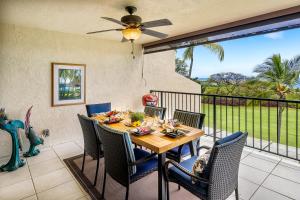 a dining room with a table and chairs on a balcony at Country Club Villas 311 in Kailua-Kona