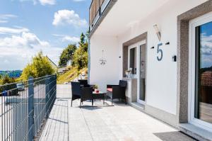 een patio met een tafel en stoelen op een balkon bij Neu stilvoll komplett Ausgestattet Fewo Gratis Wein und Getränke bei Ankunft in Saldenburg