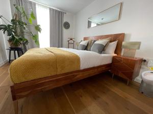 a bedroom with a large bed with a yellow blanket at Peloton Organic Health Apartment in Angel, Old Street, Islington in London