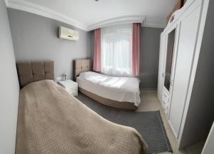 een kleine slaapkamer met een bed en een raam bij Side Oasis Residence 2+1 (Manavgat/Antalya). in Side