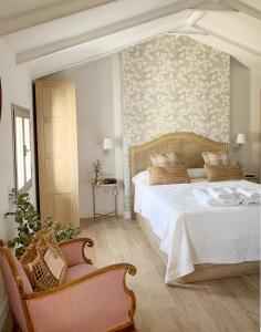 a bedroom with a large white bed and a chair at Syvyle in Cazorla