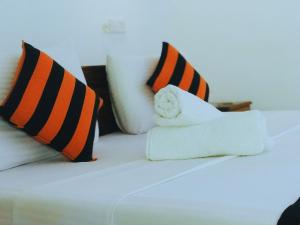 a white bed with pillows on top of it at Sigiriya Ranasinghe Nature Villa in Sigiriya