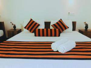 ein Schlafzimmer mit einem Bett mit zwei Handtüchern darauf in der Unterkunft Sigiriya Ranasinghe Nature Villa in Sigiriya