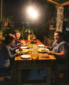 un grupo de personas sentadas en una mesa comiendo comida en Oro y Luna Lodge, en Carlos Julio Arosemena Tola