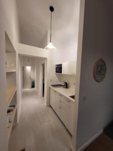 una cucina con armadi bianchi e un corridoio di Apartmani J&I a Pakoštane