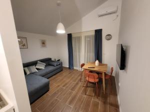 uma sala de estar com um sofá e uma mesa em Apartmani J&I em Pakoštane