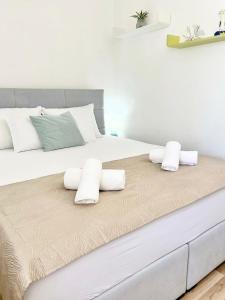 a bedroom with a large white bed with towels on it at Luxury apartment Aura in Supetar