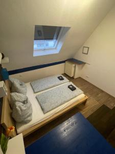 um pequeno quarto com 2 camas num sótão em #6 Familienzimmer mit Gemeinschaftsbad em Memmingen