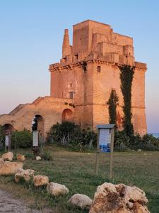 an old building with rocks in front of it at Mare Sole Vento 38 Punta Prosciutto in Torre Colimena