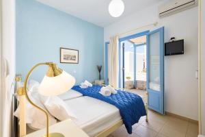 a blue bedroom with a bed and a window at Kostantis Vacation Home 1 in Ambelas