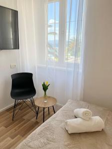 a bedroom with a bed and a chair and a window at Luxury apartment Aura in Supetar