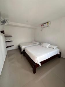 1 dormitorio con 2 camas en una habitación en Hotel Casa Evan en Mompox