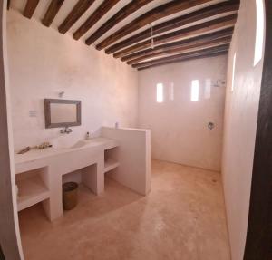 a bathroom with a sink and a mirror at Amma's House in Lamu