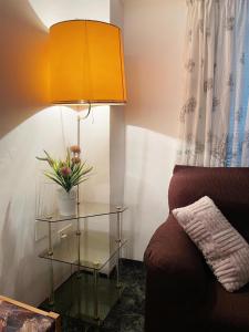 une lampe avec une table en verre à côté d'un canapé dans l'établissement Casa ' A ca Paca ', à Lanjarón