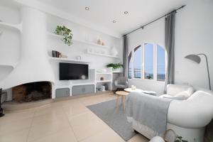 sala de estar con sofá blanco y chimenea en Preciosa casa frente al mar, en Montgat
