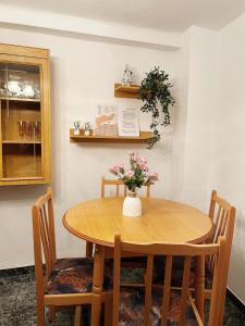 uma mesa de jantar com um vaso de flores em Casa ' A ca Paca ' em Lanjarón