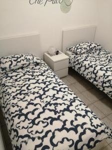 1 Schlafzimmer mit 2 Betten und einer weißen und schwarzen Decke in der Unterkunft B&B COLLE TARIGNI in Manoppello