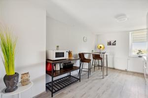 cocina y comedor con mesa y microondas en Apartment-Studio, Netflix-TV für bis zu 2 Personen en Halberstadt