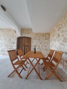 a wooden table and four chairs in a room at Flower in Poljica