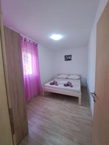 a small room with a bed and a window at Flower in Poljica