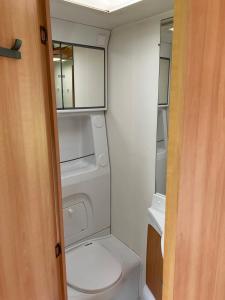 a small bathroom with a toilet and a mirror at Caravan met wijds uitzicht in Kuinre