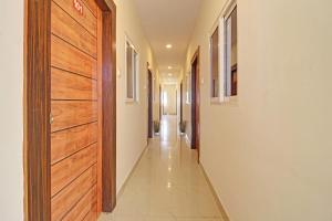 a hallway with a wooden door and a tile floor at Flagship Hotel R Square in Warangal