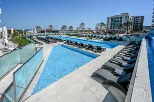 una piscina con tumbonas en un edificio en Crystal Beach 228 - Infinity Pool & Spa Resort, en Mamaia Nord – Năvodari