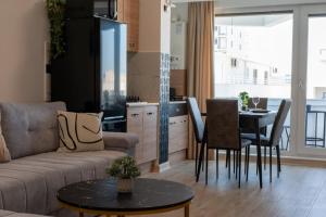 een woonkamer met een bank en een tafel bij Crystal Beach - Infinity Pool & Spa Resort in Mamaia Nord – Năvodari