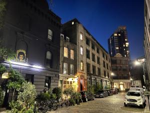 una calle de la ciudad por la noche con coches estacionados al lado de los edificios en Peloton Organic Health Apartment in Angel, Old Street, Islington, en Londres