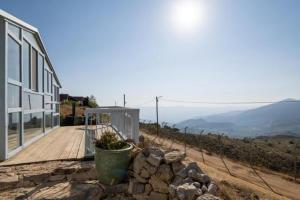 uma casa numa colina com um deque e um edifício em הטירות הנעות ברוח em Nimrod