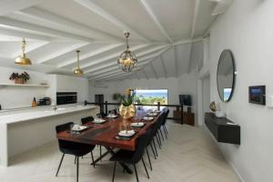 a dining room with a long table and chairs at Dunn Dreamin Barbados in Saint James