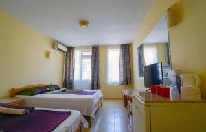 a hotel room with two beds and a television at Fener Guest House in Pomorie