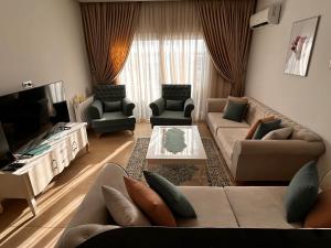 uma sala de estar com um sofá e uma televisão em Wunderschönes Apartment im Palm Lake Resort - S+2 très haut standing für bis zu 5 Personen em Monastir