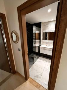 uma casa de banho com um lavatório e um espelho em Wunderschönes Apartment im Palm Lake Resort - S+2 très haut standing für bis zu 5 Personen em Monastir