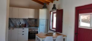 kuchnia ze stołem i krzesłami oraz czerwonymi drzwiami w obiekcie Casa das Rosas w mieście Crato