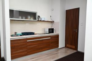 uma cozinha com armários de madeira e um micro-ondas em Lara Five em Hajdúszoboszló