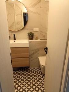 a bathroom with a sink and a toilet and a mirror at Modern Cozy Apartment - NEW in Kyustendil