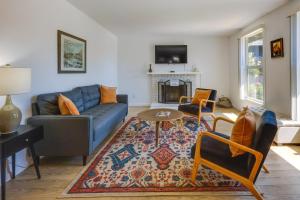 sala de estar con sofá azul y chimenea en Inviting Home with Patio Walk to Downtown Novato!, en Novato