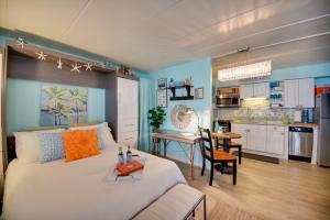 a bedroom with a white bed and a kitchen at Chic Virginia Beach Retreat - Pool, Steps to Beach in Virginia Beach