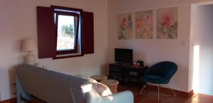 - un salon avec un canapé et une fenêtre dans l'établissement Casa das Rosas, à Crato