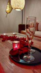 una mesa con una copa de vino y rosas rojas. en La bulle D'orée, en Chaudfontaine