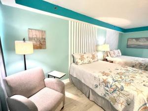 une chambre avec un lit, une chaise et un canapé dans l'établissement Daytona Beach Resort Oceanfront 1 Bedroom Suite, 2 Queen Beds, à Daytona Beach