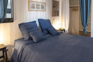 a bedroom with a blue bed with blue pillows at La Martinoise Studio in Saint-Martin-de-Ré