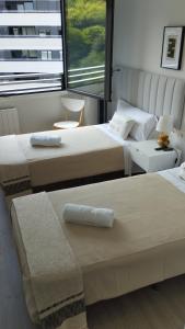 a bedroom with two beds and a window at Habitación con baño privado Bilbao in Bilbao